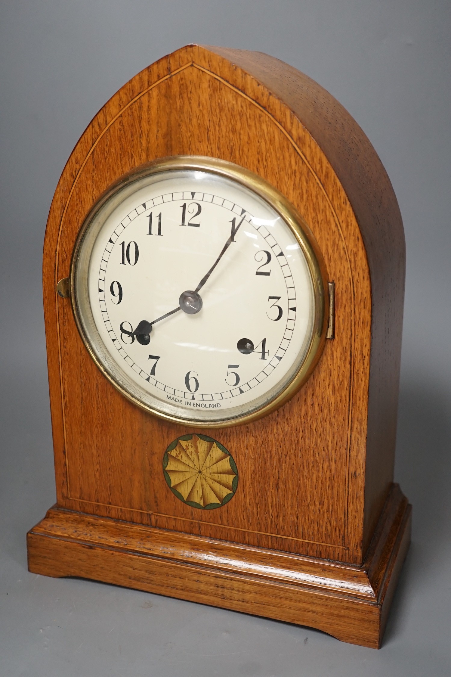 A pair of ebony rhinoceros book ends, together with an Edwardian oak lancet mantel clock, 35cm high